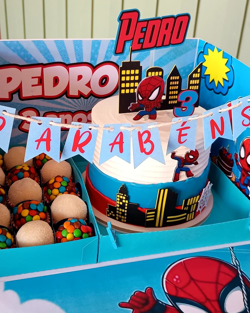 Festa na caixa com tema de super-herói, bolo com topo personalizado e docinhos coloridos