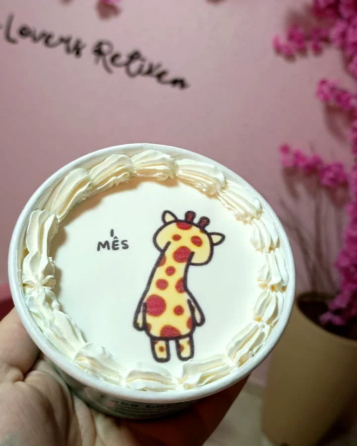 Bolinho no pote de mesversário com uma girafinha e a frase 1 mês